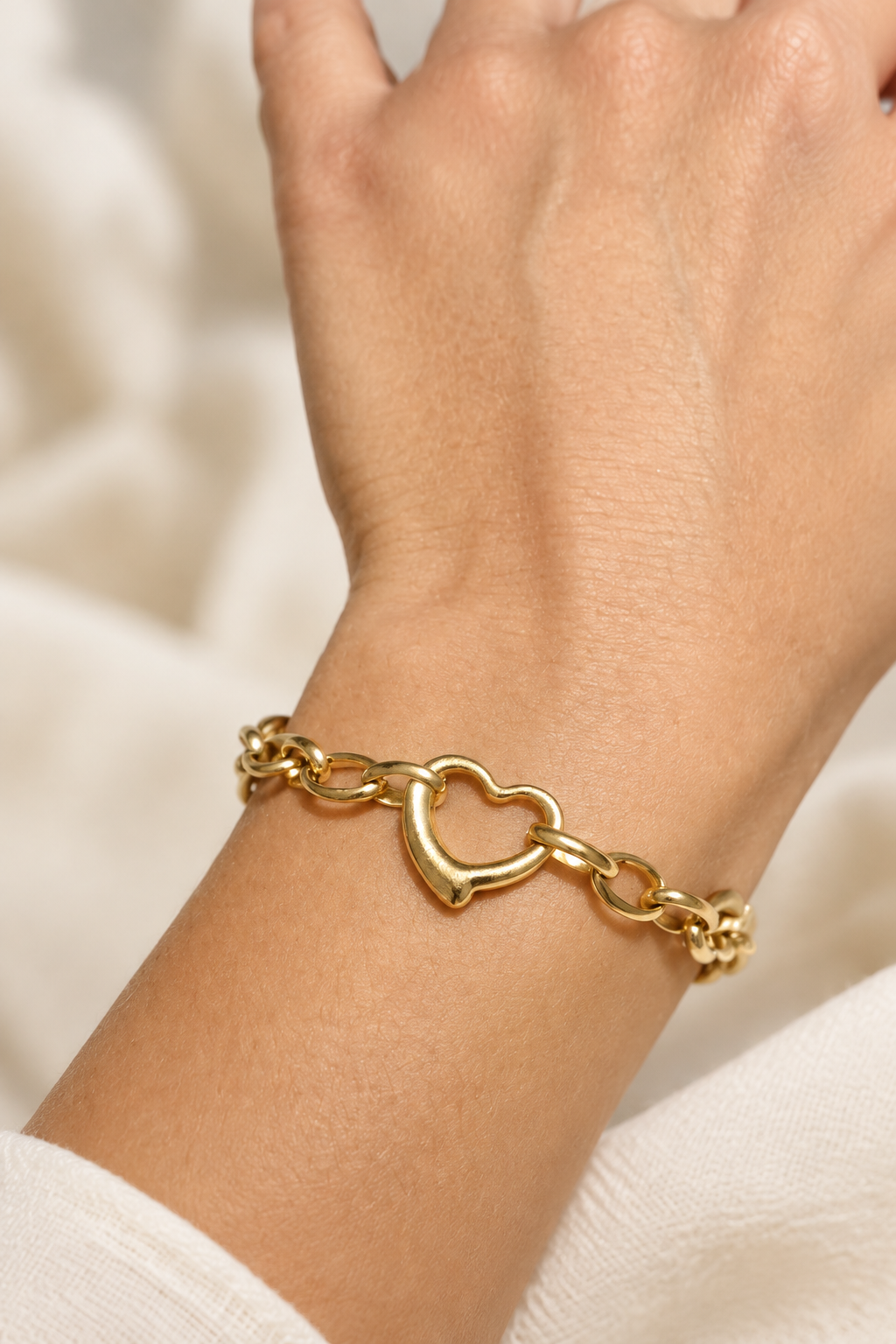 Bracelet cœur doré porté, photo lumineuse avec arrière-plan flouté