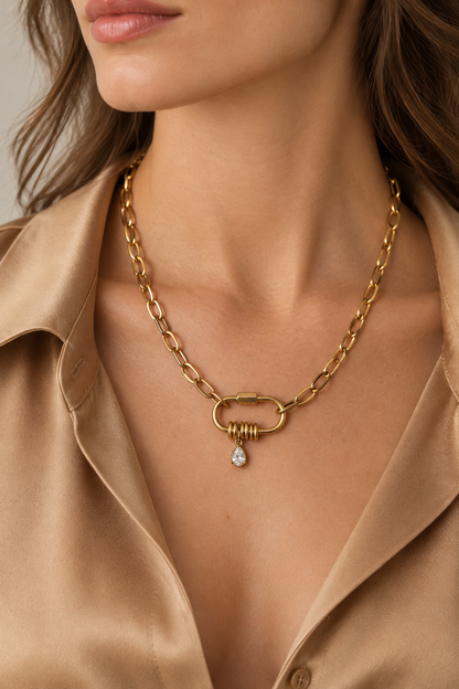 Collier doré sur mannequin portant une chemise en soie camel