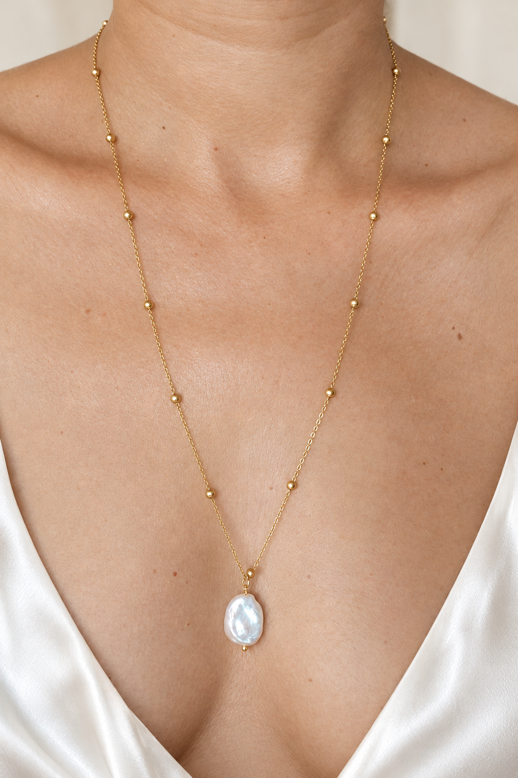 Collier mis en valeur avec une tenue en soie blanche