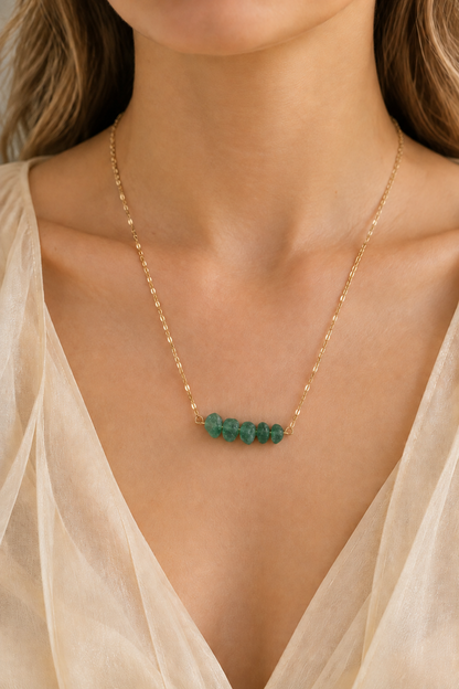 Collier à pierres vertes légèrement plus petites, porté avec un haut doré
